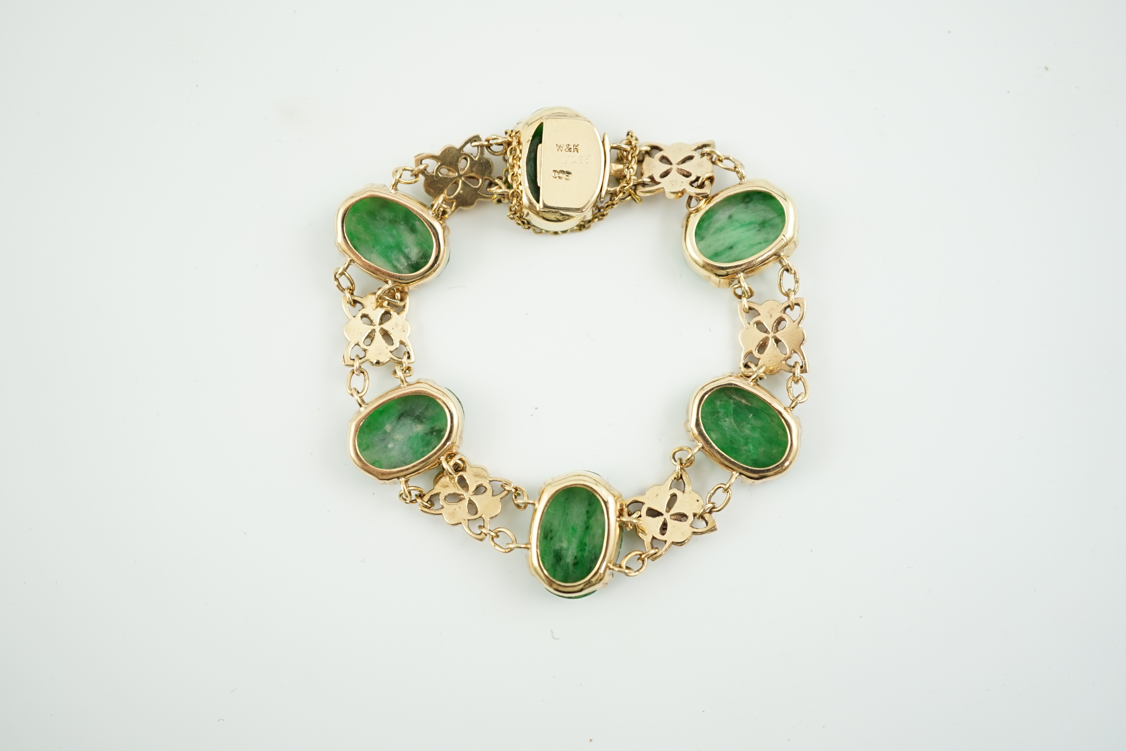 An early 20th century 9ct gold butterfly link and six stone carved jade set bracelet